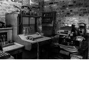 Historische telefooncentrale met oude toestellen en schakelpaneel, vastgelegd in zwart-wit.