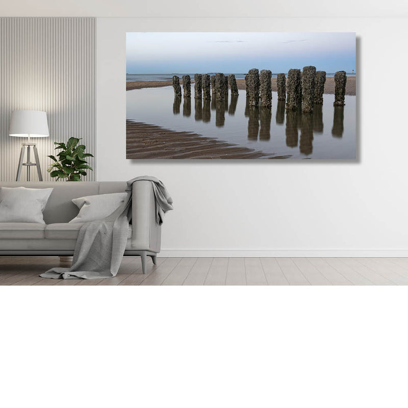 Mosselbedekte palen in getijdenwater