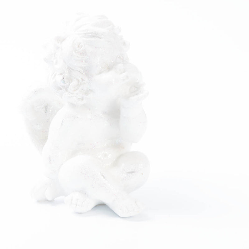De foto toont een witte engelenfiguur die in een zachte high-key belichting volledig opgaat in een bijna totaal witte achtergrond. 