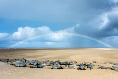 Regenboog boven het wad, de foto