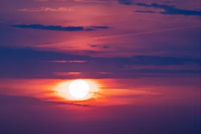 Witte Zon tussen Paarse Wolken, de foto