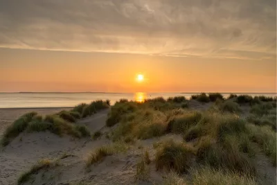 Zonsopgang boven de duinen in Texel, de foto