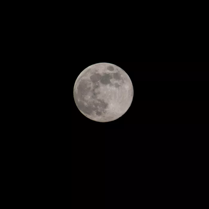 Volle maan met scherpe kraters in het midden van een zwarte nachthemel