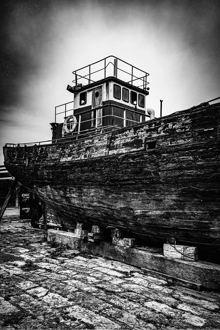 Een oud verlaten schip rust na vele avonturen op zee uit aan wal. Het verweerde hout, het roestige ijzer, ze vertellen een hele geschiedenis.