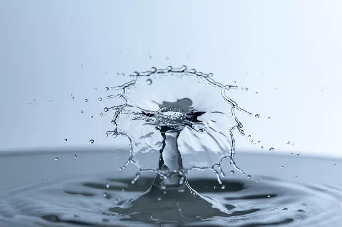 Kroonvormig waterscherm met druppelrand rond een waterzuil, in koele blauwe tinten