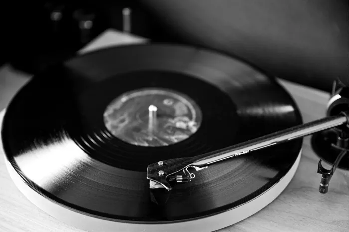 Platenspeler met een zwarte vinylplaat en de naald op de groeven, in zwart-wit