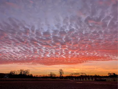 Roze wolken boven een oranje gloed, de foto