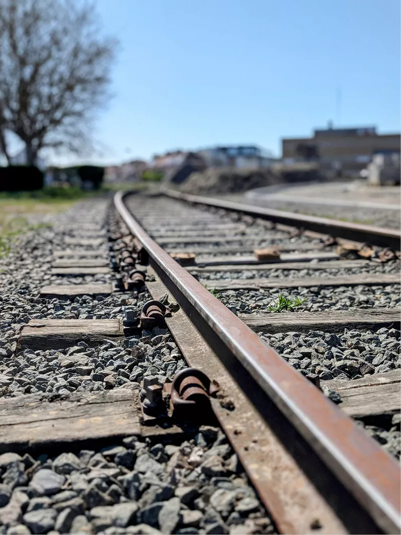 Roestige rails en houten dwarsliggers in het grind van een buiten gebruik gestelde spoorlijn
