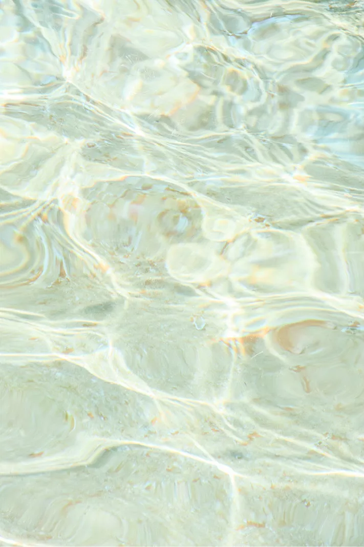 Helder turquoise zeewater met golvende lichtlijnen van de zon