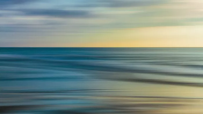 Abstracte zeegezicht met horizontale vegen in blauwgrijs en zachtgeel onder een bewolkte lucht, met een rechte horizon.