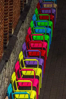Kleurrijke Stoelen langs de Muur, de foto