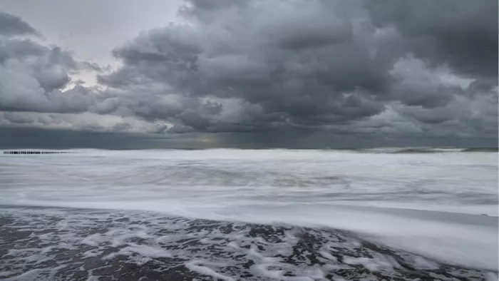 Zee bij vloed en storm, met zacht vervloeiend water, schuim en donkere wolken